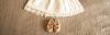 Sprüche zur Taufe: Feierliches weißes Kleid und feierliche Schuhe eines Kindes auf einer braunen Decke